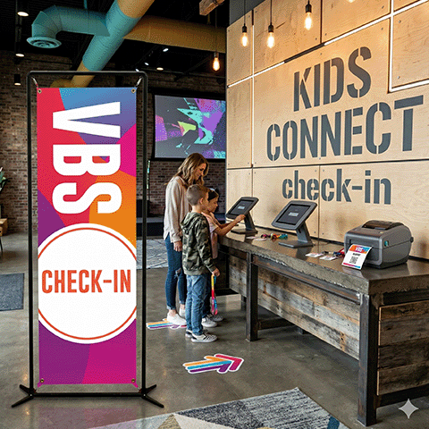 Vertical 2x6 Indoor Banner placed next to a modern church check-in desk